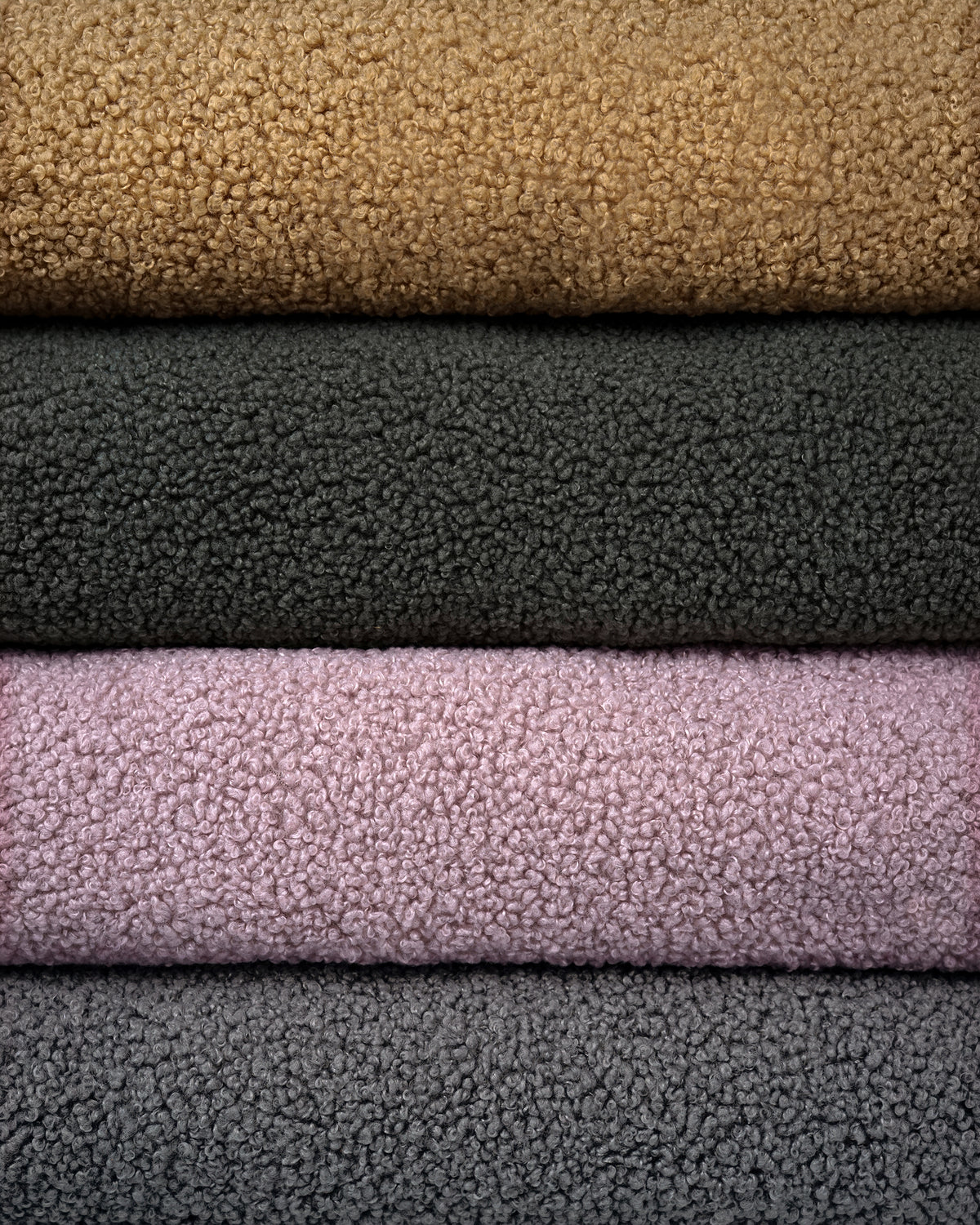Stacked bouclé fabrics in camel, forest green, powder pink and grey