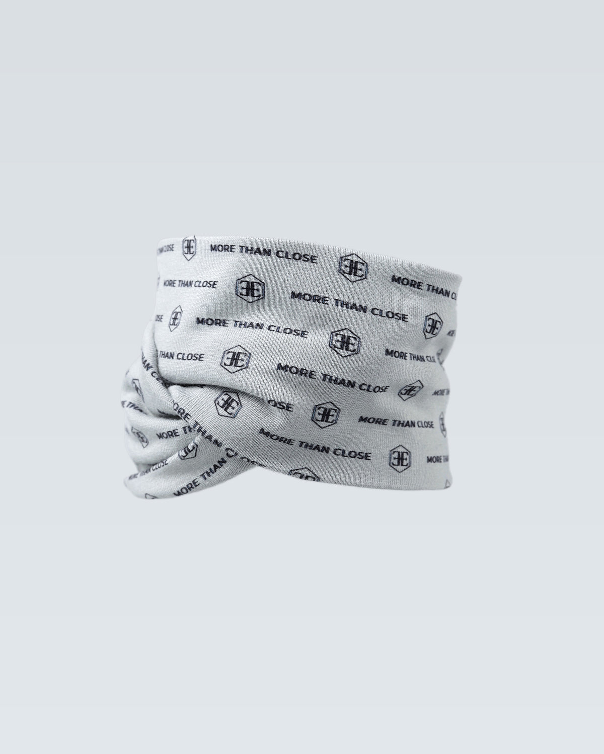The light grey snood stands rolled on a pale background, its repeated wordmark print covering the fabric