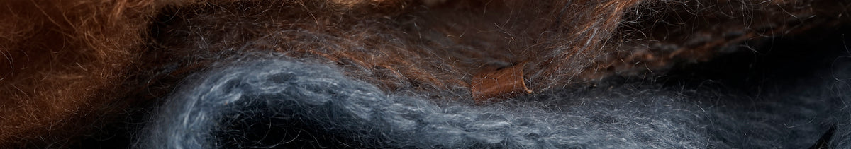 Close-up of mohair and silk knit with a small wave-shaped leather label.