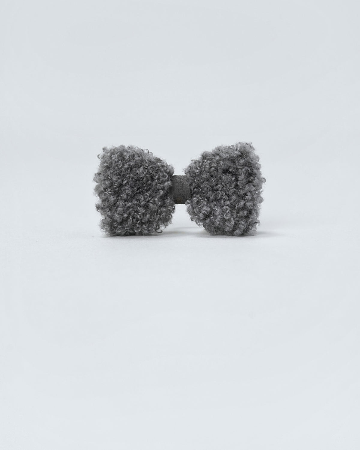 Front view of a grey bouclé dog hair bow