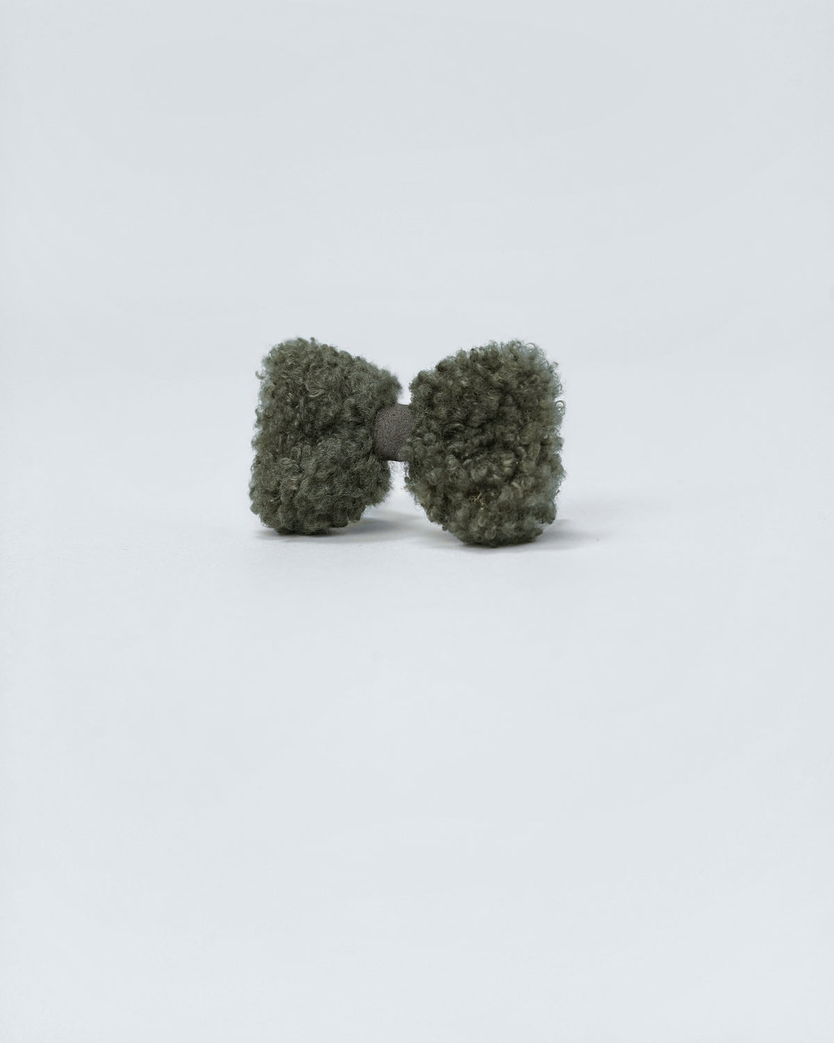 Angled view of a forest green bouclé bow